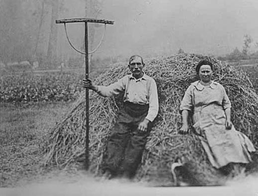 Farmers leaning on a pile of hay