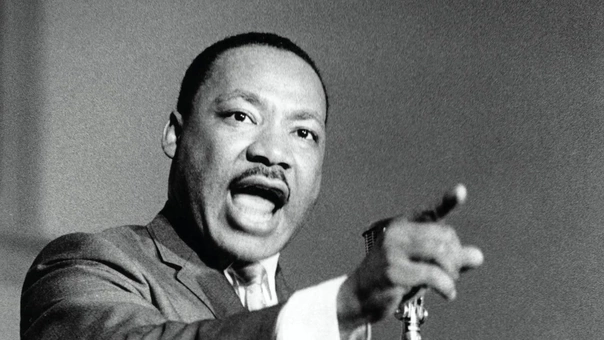 Martin Luther King Jr. speaking into microphone